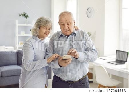 Senior couple, retired old man, woman elderly peple using together mobile phone text, communicate Senior couple, retired old man, woman elderly peple using together mobile phone text, communicate 127305518