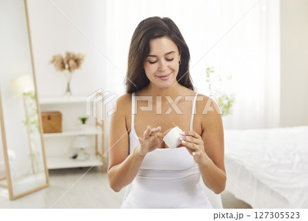 Woman Applying Cream In The Morning In Her Bedroom 127305523