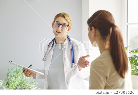 Female doctor talking sharing health tests laboratory results to female patient explaining  127305526