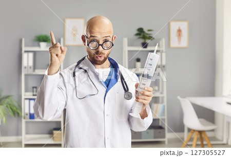Serious Doctor or Nurse in Funny Glasses Holding a Large Syringe 127305527