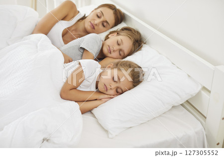 Mother And Children Sleeping Together In Bed At Home Early In The Morning 127305552