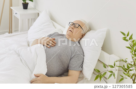 Elderly Man Sleeping Peacefully In Bed During Early Morning At Home 127305585