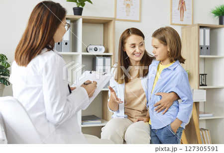 Portrait of a little girl patient with her mother talking with pediatrician doctor in clinic. Portrait of a little girl patient with her mother talking with pediatrician doctor in clinic. 127305591