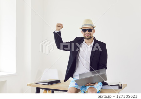 Man sitting in office and booking tickets for summer vacation online via laptop Man sitting in office and booking tickets for summer vacation online via laptop 127305623