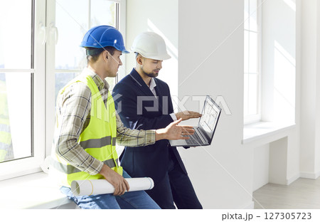 Architect, engineer or designer showing foreman design project on laptop, discussing renovation plan Architect, engineer or designer showing foreman design project on laptop, discussing renovation plan 127305723