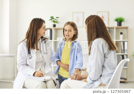 Portrait of a little girl patient with her mother talking with pediatrician doctor in clinic. Portrait of a little girl patient with her mother talking with pediatrician doctor in clinic. 127305867