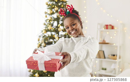 Portrait Of African American Woman With A Gift Box During Christmas Or New Year Portrait Of African American Woman With A Gift Box During Christmas Or New Year 127305868
