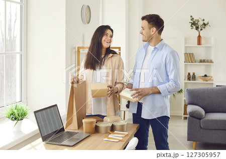 Happy smiling young couple unpacking their lunch from takeaway meal delivery service 127305957