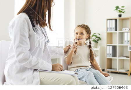 Portrait of child patient talking with female doctor talking during medical examination in clinic Portrait of child patient talking with female doctor talking during medical examination in clinic 127306468