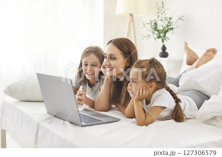 Happy family laptop watching, online mother on weekend morning, kid girl, boy, loving mum Happy family laptop watching, online mother on weekend morning, kid girl, boy, loving mum 127306579