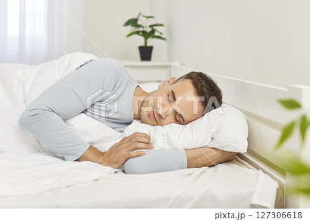 Close up of young man sleeping in sweet dreams on bed in the morning at home. Close up of young man sleeping in sweet dreams on bed in the morning at home. 127306618