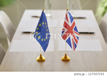 Negotiations between European Union and Great Britain in boardroom with flags on table. 127307291