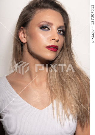 Beautiful woman close-up studio portrait with white blouse and fancy vivid make-up Beautiful woman close-up studio portrait with white blouse and fancy vivid make-up 127307313