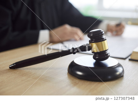 Gavel wooden hammer at desk close up, judge sentences in court of law, accuses guilty, proclamation 127307348