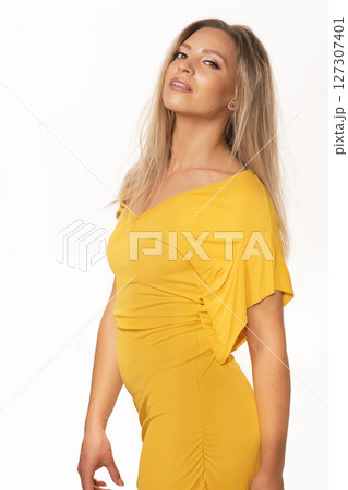 Beautiful woman with yellow dress studio portrait in white background 127307401