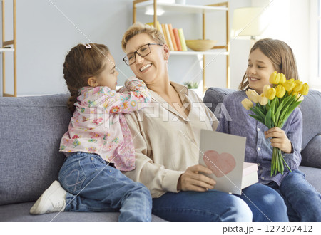 Happy smiling children congratulating grandmother with Women Day or Mothers day Happy smiling children congratulating grandmother with Women Day or Mothers day 127307412