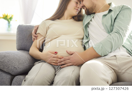 Loving couple sitting belly hug, future parents expecting first baby close at home, caring  127307426