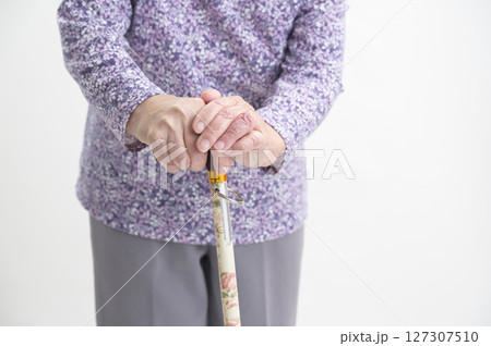 杖を持つおばあさんの手元 127307510