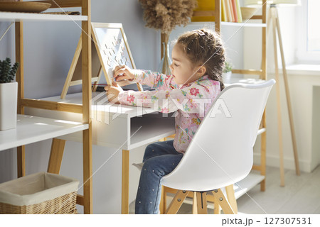 Small little girl playing, learning at home sitting in own room, happy baby and children furniture 127307531
