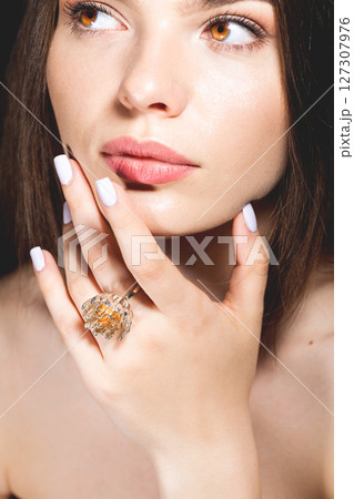 Close-up studio portrait of beautiful woman with fancy golden ring Close-up studio portrait of beautiful woman with fancy golden ring 127307976