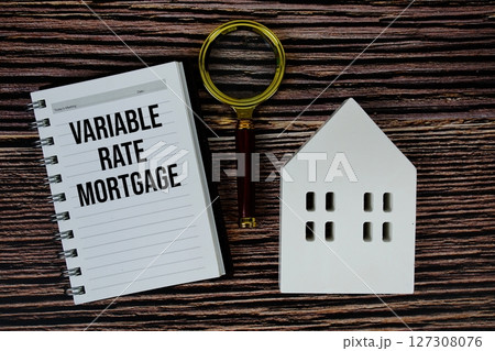 Variable Rate Mortgage text on paper notebook with white house model and magnifying glass on wood background Variable Rate Mortgage text on paper notebook with white house model and magnifying glass on wood background 127308076