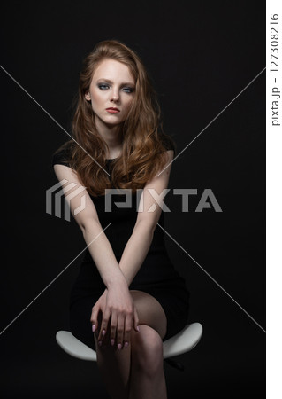 Beautiful woman studio portrait in black background 127308216