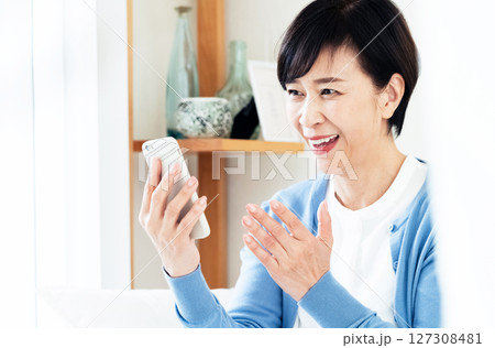 スマホでビデオ通話する中高年女性 127308481