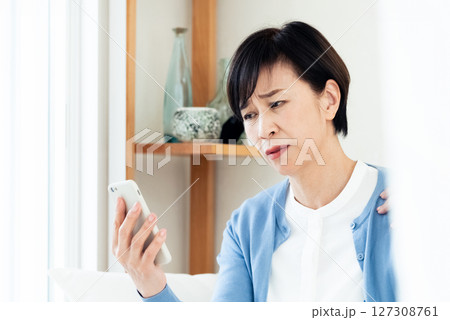スマホでビデオ通話する中高年女性 スマホでビデオ通話する中高年女性 127308761