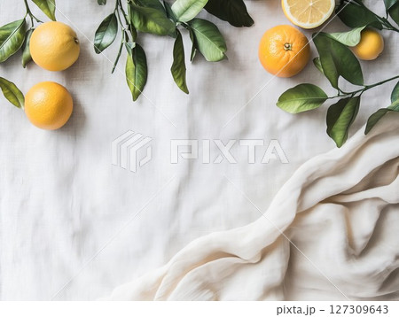 Oranges and lemon slices with green leaves on white cloth. Bright display for culinary or wellness themes, great for fresh or rustic ideas. Perfect for natural or fruit visuals. Oranges and lemon slices with green leaves on white cloth. Bright display for culinary or wellness themes, great for fresh or rustic ideas. Perfect for natural or fruit visuals. 127309643
