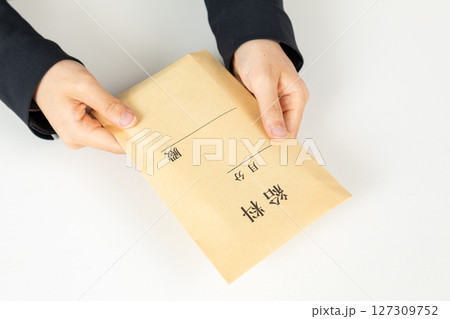 給料袋を受け取る女性の手元01 127309752