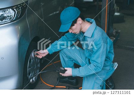 タイヤ空気圧点検をする自動車整備士 127311101