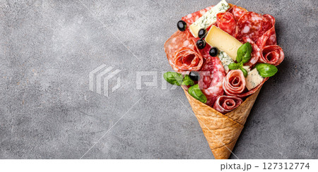 stunning charcuterie cone filled with cured meats, cheese, and herbs 127312774