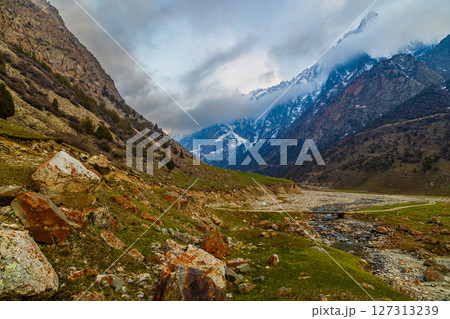 Majestic mountains and serene river in peaceful nature setting 127313239