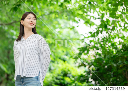 新緑の中に立つ笑顔の女性 127314289