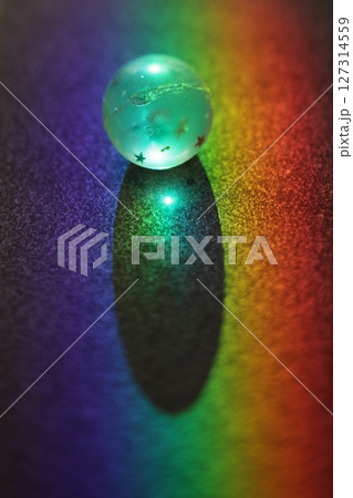 Small, glowing ball sits on a dark surface Small, glowing ball sits on a dark surface 127314559