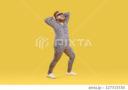 Funny happy plus size man wearing crazy leopard pajamas having fun in fashion studio 127315530