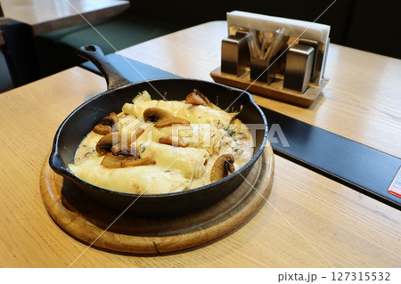 Satisfy cravings with baked cheese and flavorful mushrooms, cooked in a cast iron skillet 127315532