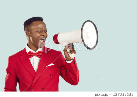 Stylish elegant ethnic man with megaphone making loud announcement on pastel light blue background. Stylish elegant ethnic man with megaphone making loud announcement on pastel light blue background. 127315533