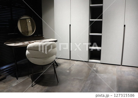 Discover a Modern Minimalist Dressing Area with a Stylish Chair and Practical Storage solutions 127315586
