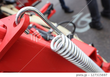 A CloseUp Image of a Metal Coil Spring Within a Piece of Machinery and Equipment 127315697
