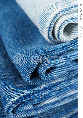 Pile of textiles in various shades of blue, stacked jeans fabric on top of each other in store Pile of textiles in various shades of blue, stacked jeans fabric on top of each other in store 127315714