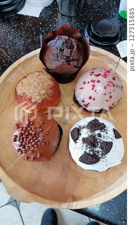 A Beautifully Arranged Tray Featuring Delicious Assorted Muffins and Sweet Donuts A Beautifully Arranged Tray Featuring Delicious Assorted Muffins and Sweet Donuts 127315885