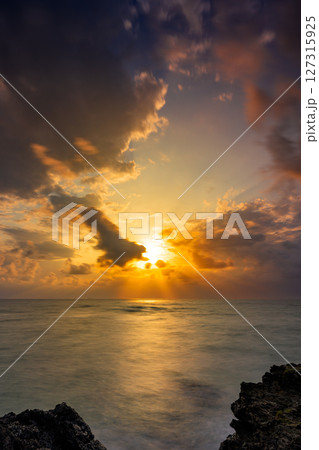 岩場の間から夕日が沈む石垣島観音崎の幻想風景 127315925