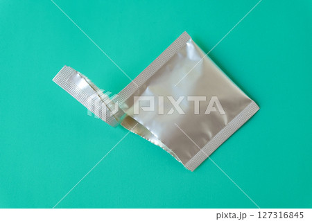 Open aluminum bag lying on color background. Open aluminum bag lying on color background. 127316845