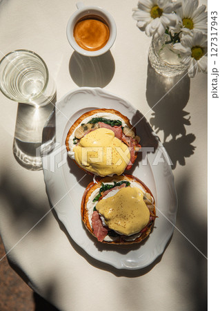 Portion of benedict eggs with sauce and brioche Portion of benedict eggs with sauce and brioche 127317943