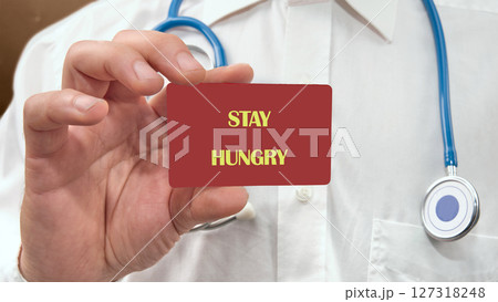 Concept Phase STAY HUNGRY on the card in the hands of a man in white clothes 127318248