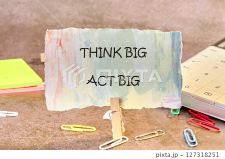 THINK BIG ACT BIG concept words written on paper, fixed in a clothespin THINK BIG ACT BIG concept words written on paper, fixed in a clothespin 127318251