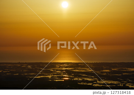 犀鶴林道から眺める夕陽に染まる手取川扇状地の水田と日本海 127318418