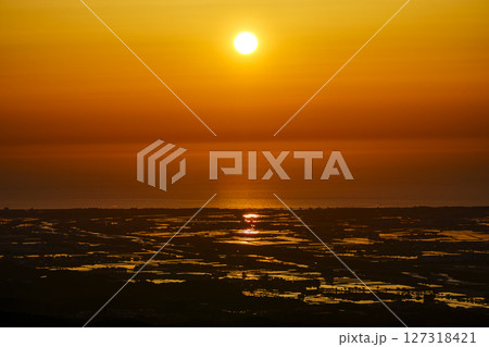 犀鶴林道から眺める夕陽に染まる手取川扇状地の水田と日本海 127318421