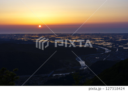 犀鶴林道から眺める夕陽に染まる手取川扇状地の水田と日本海 127318424